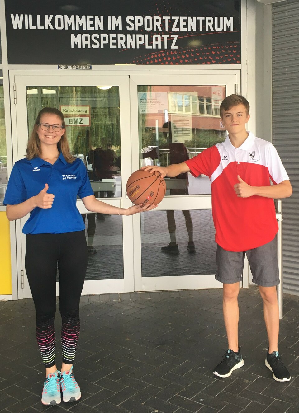Unsere FSJlerin Julia überreicht unserem neuen FSJler Niklas einen Basketball.